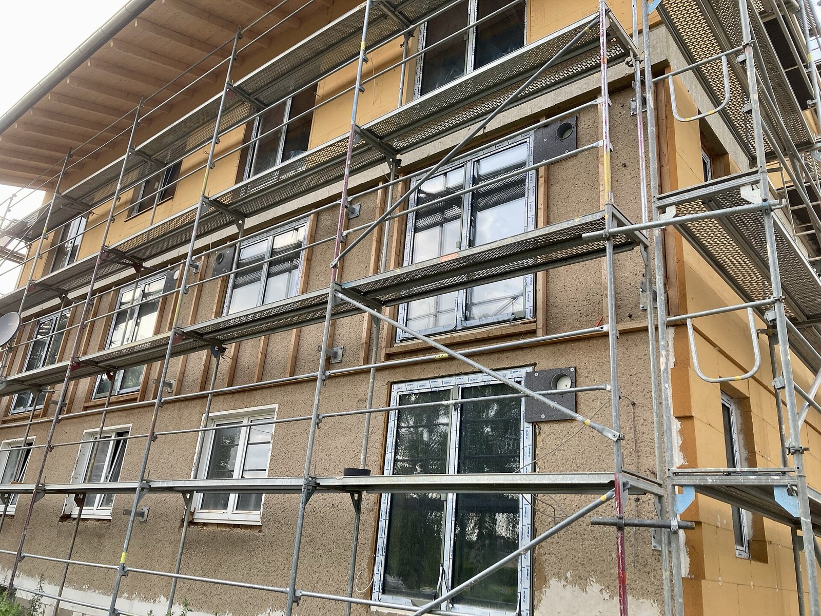 Pose de panneaux isolants en fibre de bois sur une façade